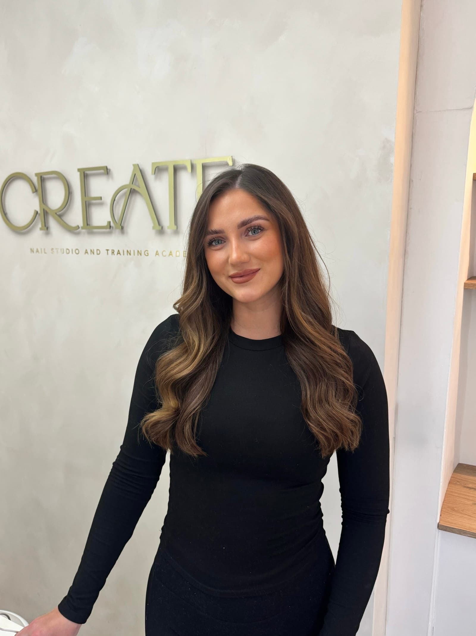 Aimee Stokes, founder and educator, in front of the CREATE studio sign