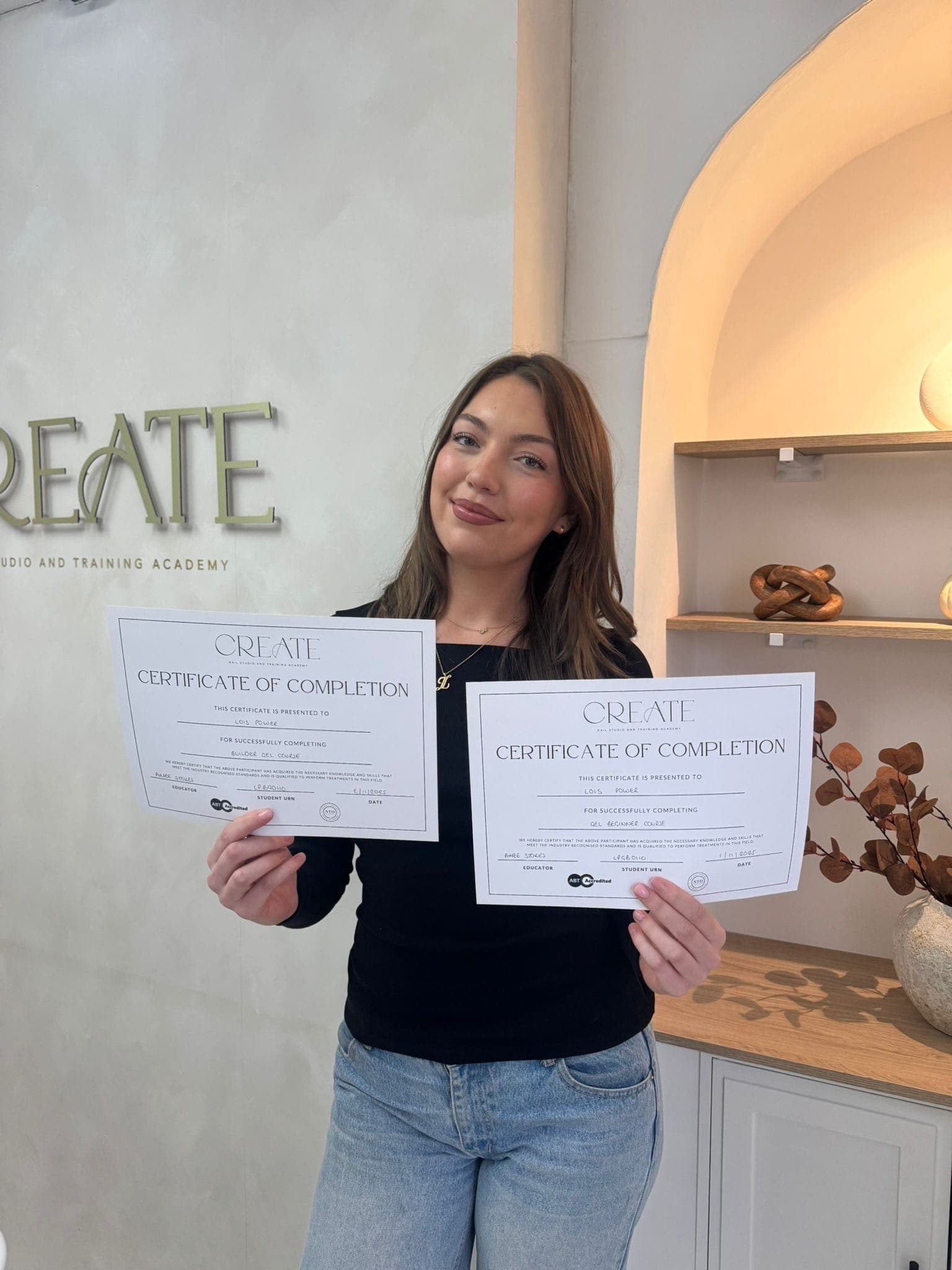 A CREATE graduate proudly holding her gel polish and builder gel certificates