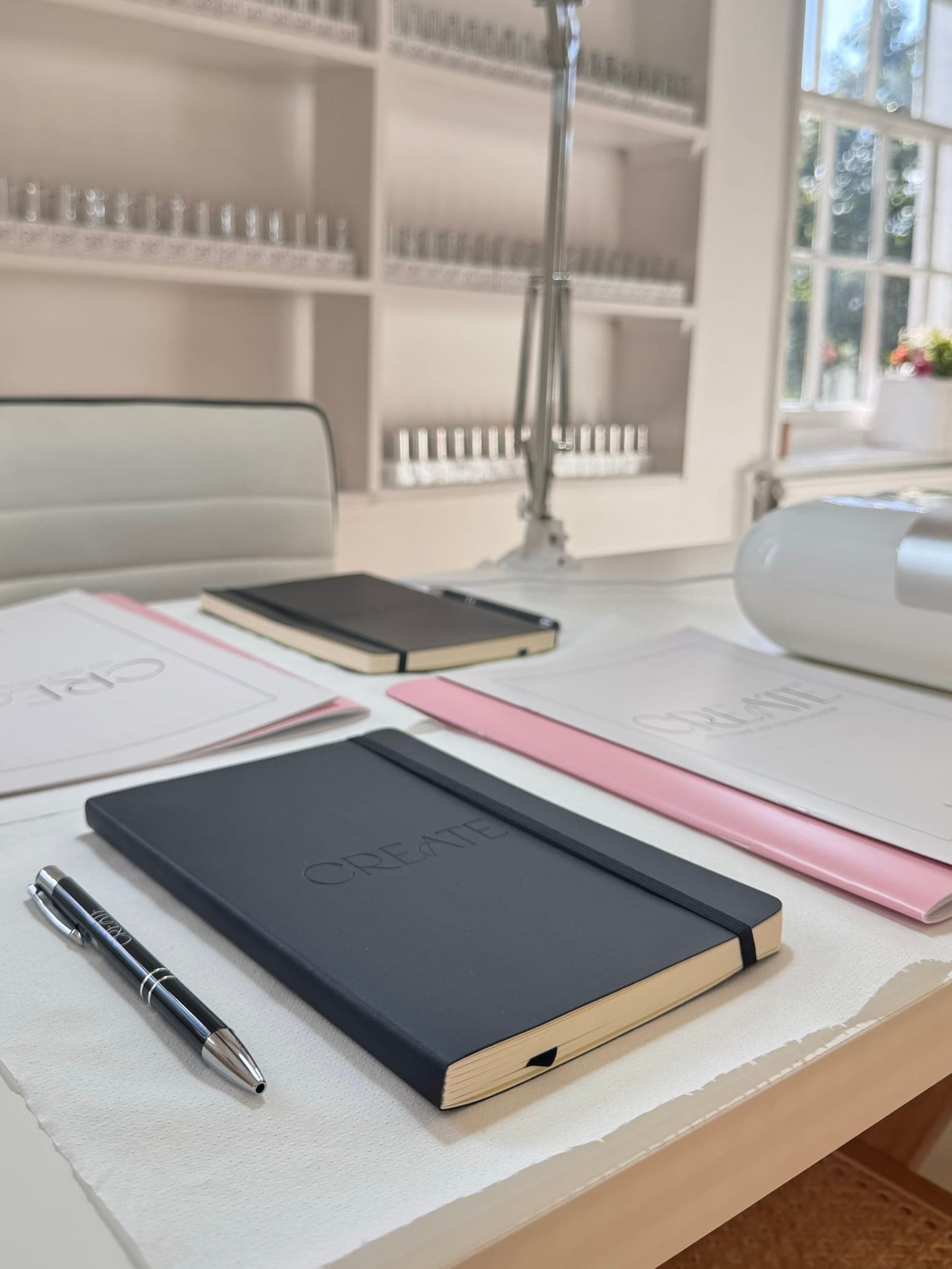 CREATE branded notebooks and training folders laid out on a studio desk